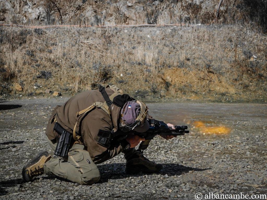 Instructor Zero réalise un tir accroupi avec flamme de bouche de canon.
